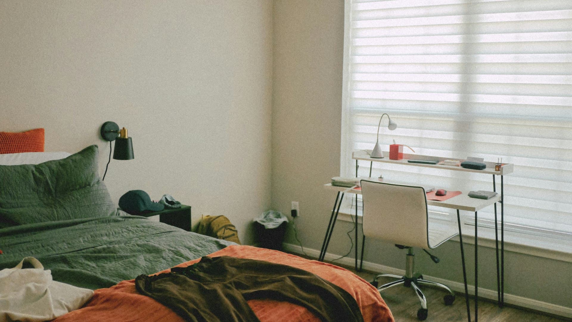A cozy, sunlit student bedroom with a study desk